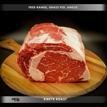 A boneless prime rib roast on a wooden cutting board, showcasing its marbled red meat.