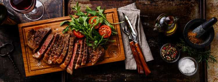 cut sirloin steak with a salad and some additions off the the side.