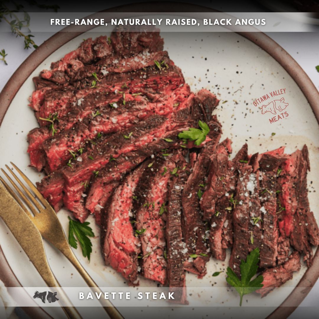 A plate of cooked bavette steak slices, seasoned with salt and pepper, garnished with parsley, with a fork and knife on the side.