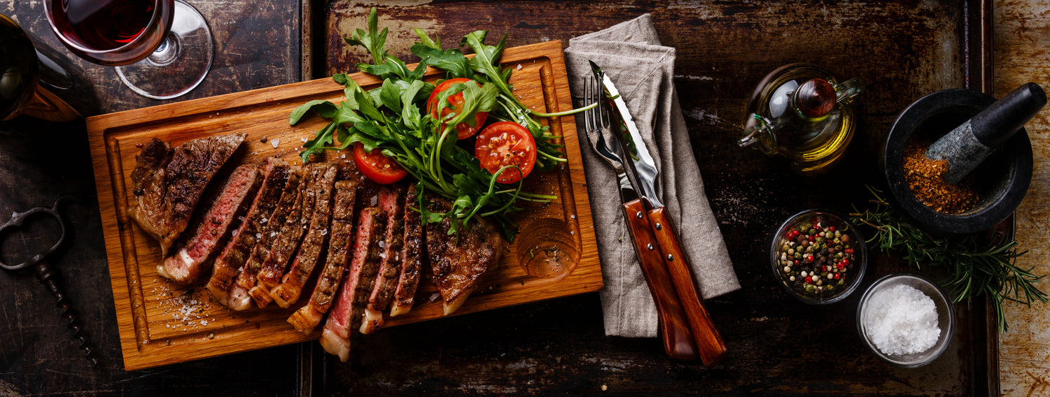 cut sirloin steak with a salad and some additions off the the side. 